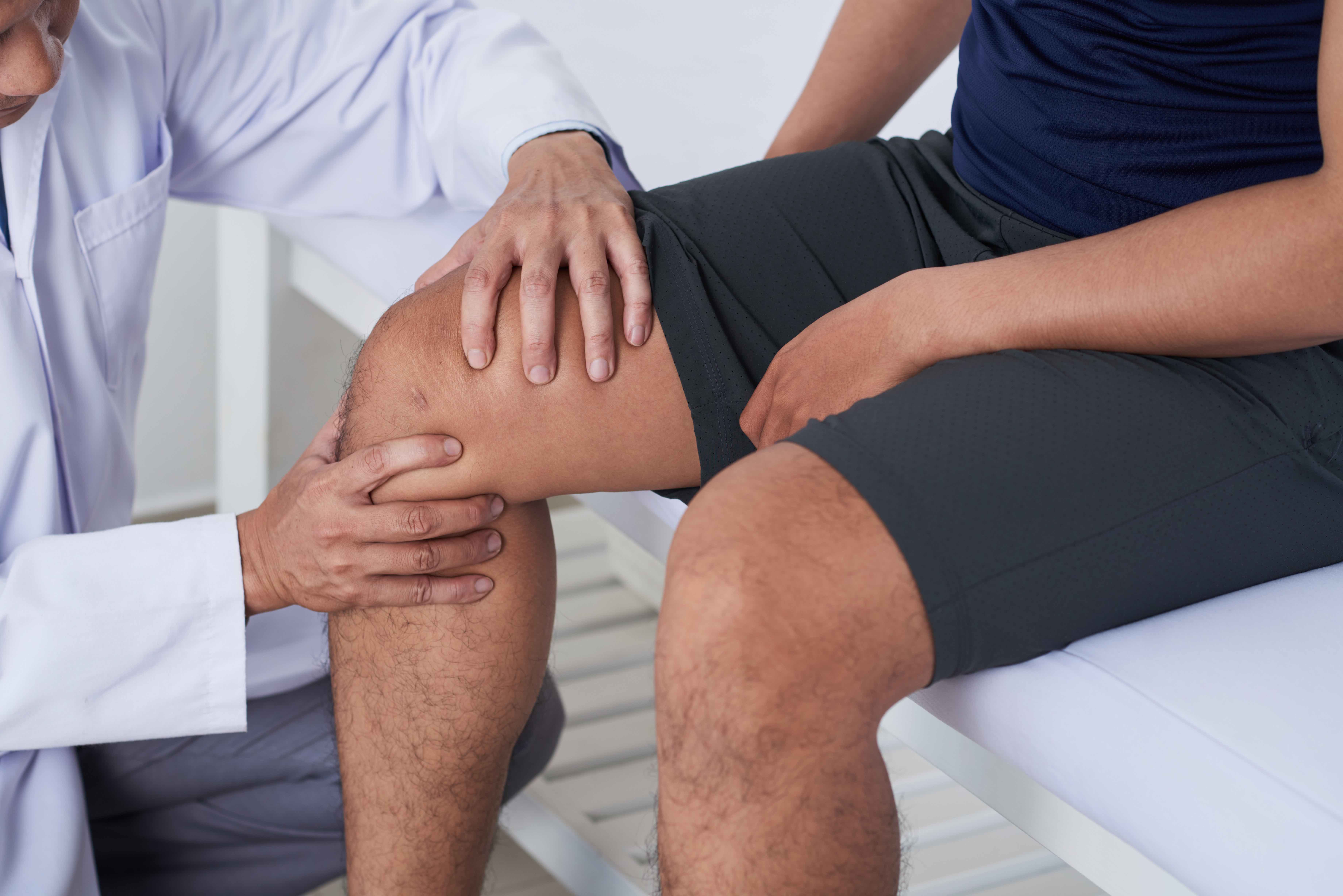Ревматология прием врача. Боль в колене. Доктор осматривает колено. Пациент с остеоартрозом.